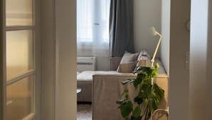 A hotel room with a bed, a desk, a chair, a lamp, and a potted plant. - Stylish Athenian Suite Near Acropolis - Balcony • AC • Walk to Everything! (Athens)