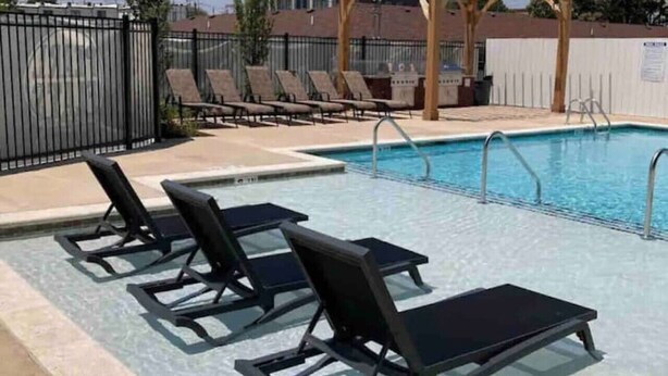 Ein Pool mit Liegestühlen und einer Pergola.