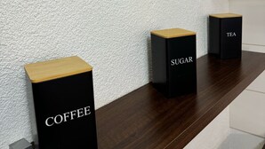 A modern interior with a wooden countertop displaying labeled containers for coffee, sugar, and tea. - C&V: 3 PP - 2 rooms +WLAN+Smart-TV+Boxspringbed (Kaiserslautern)
