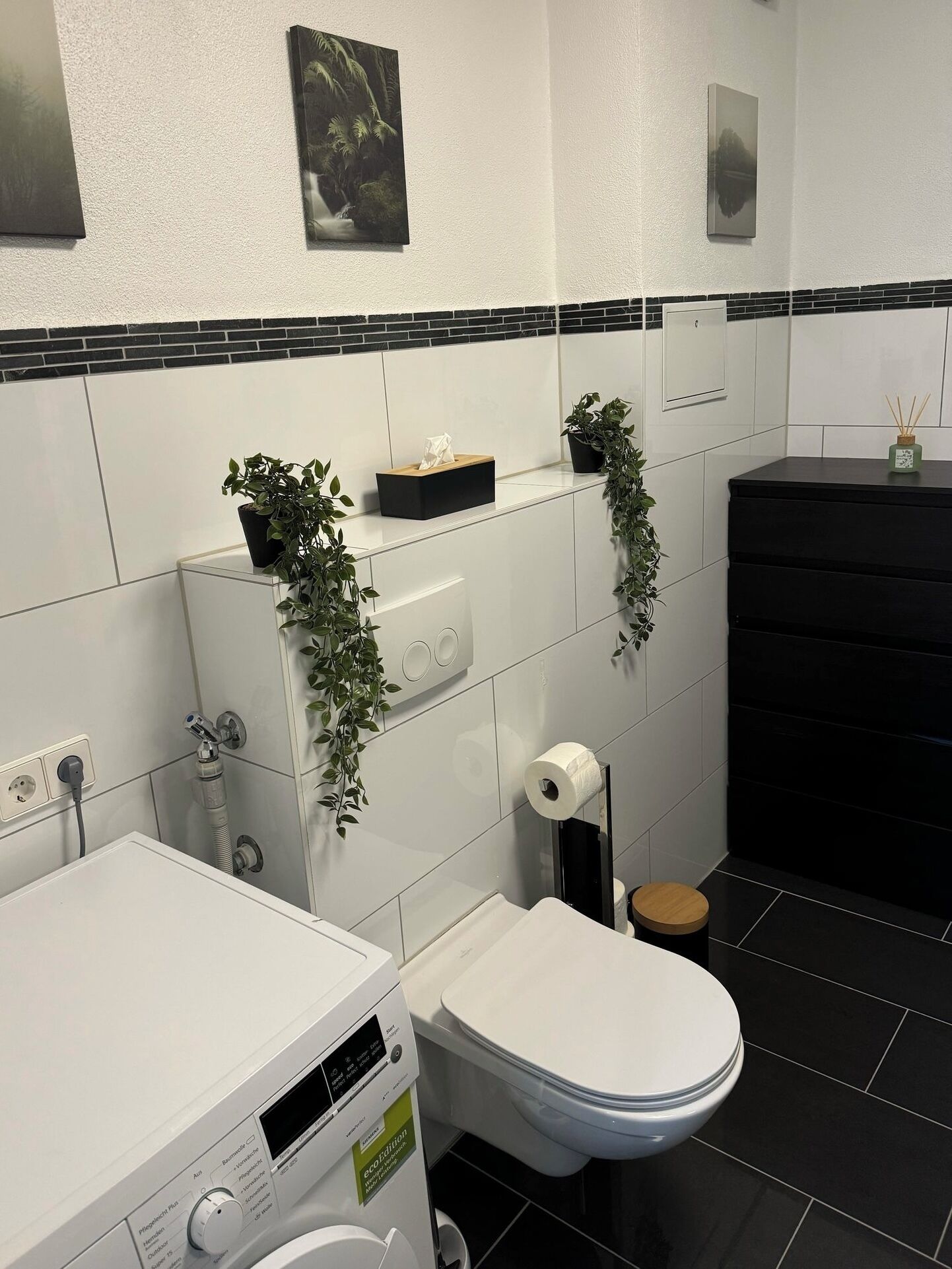 Ein modernes Badezimmer mit Toilette, Bidet und Waschmaschine.