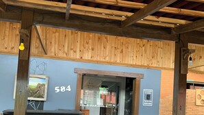 A wooden deck with a bar area, a number '584' sign, and a potted plant. - Pousada Deck 950 (Cambará do Sul)