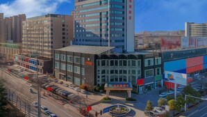 A modern hotel with a curved facade, multiple floors, and a prominent entrance. - Vienna Hotels Zao Zhuang QingTAN Road (Zaozhuang)