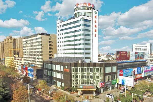 A multi-story building with a modern architectural design, featuring a prominent curved corner and a flat roof.