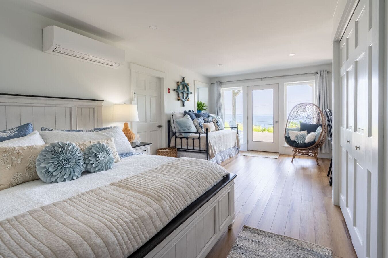 Un dormitorio con una cama grande, una silla y vistas al exterior.