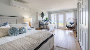 A bedroom with a large bed, a chair, and a view of the outdoors. - Lone Star Lodge - Newly Renovated Studio (Northport)