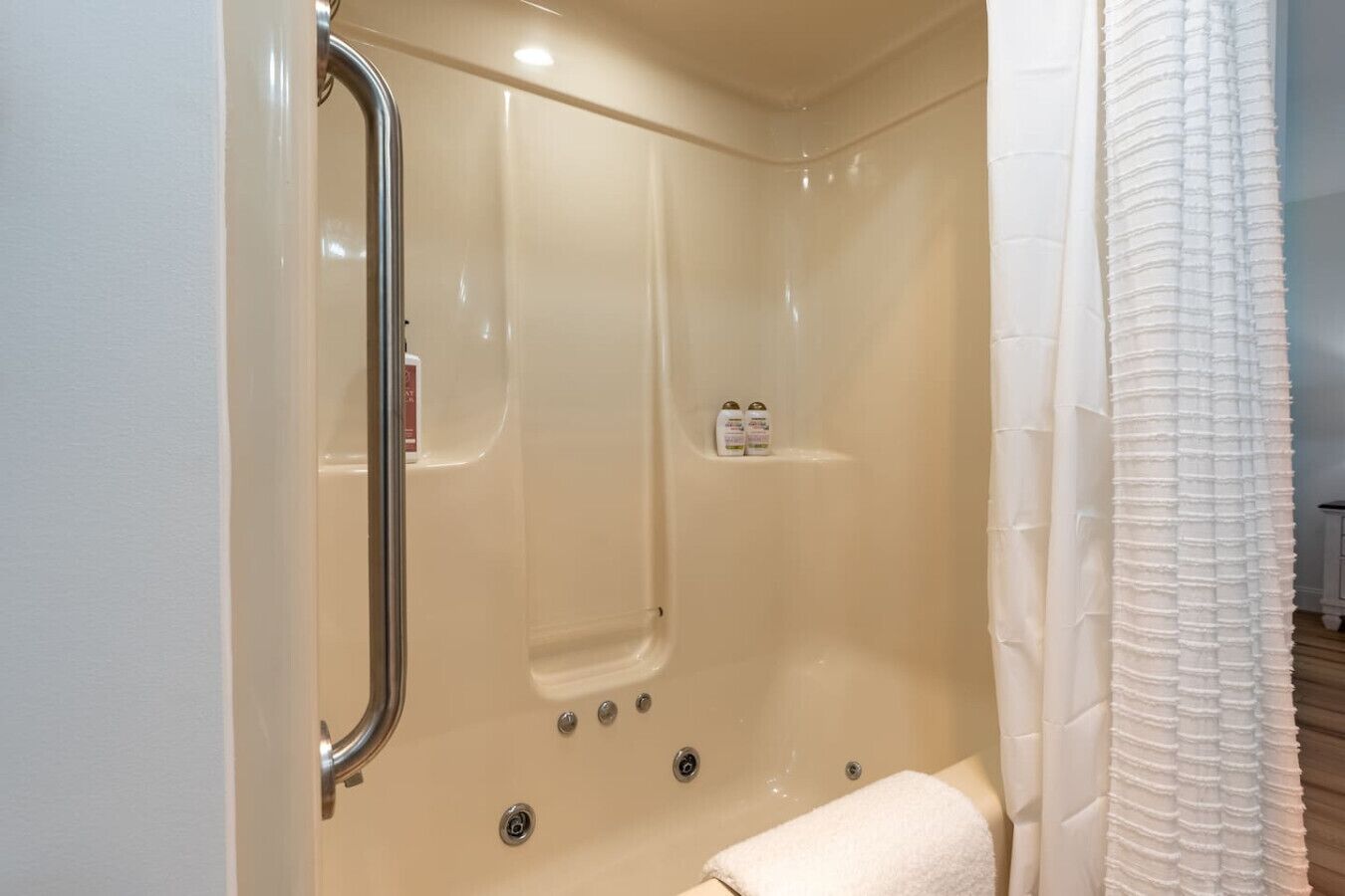 Un baño moderno con cabina de ducha, puerta de cristal y un perchero para toallas.