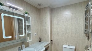 A modern bathroom with a double sink, a toilet, and a shower area. - Modern apartment 5 minutes from La Sella Golf Course (La Sella)