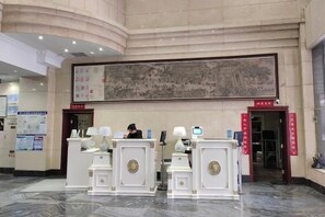 A reception area with a large traditional painting, reception desks, and a marble floor. - Jiatai Hotel (Binzhou)