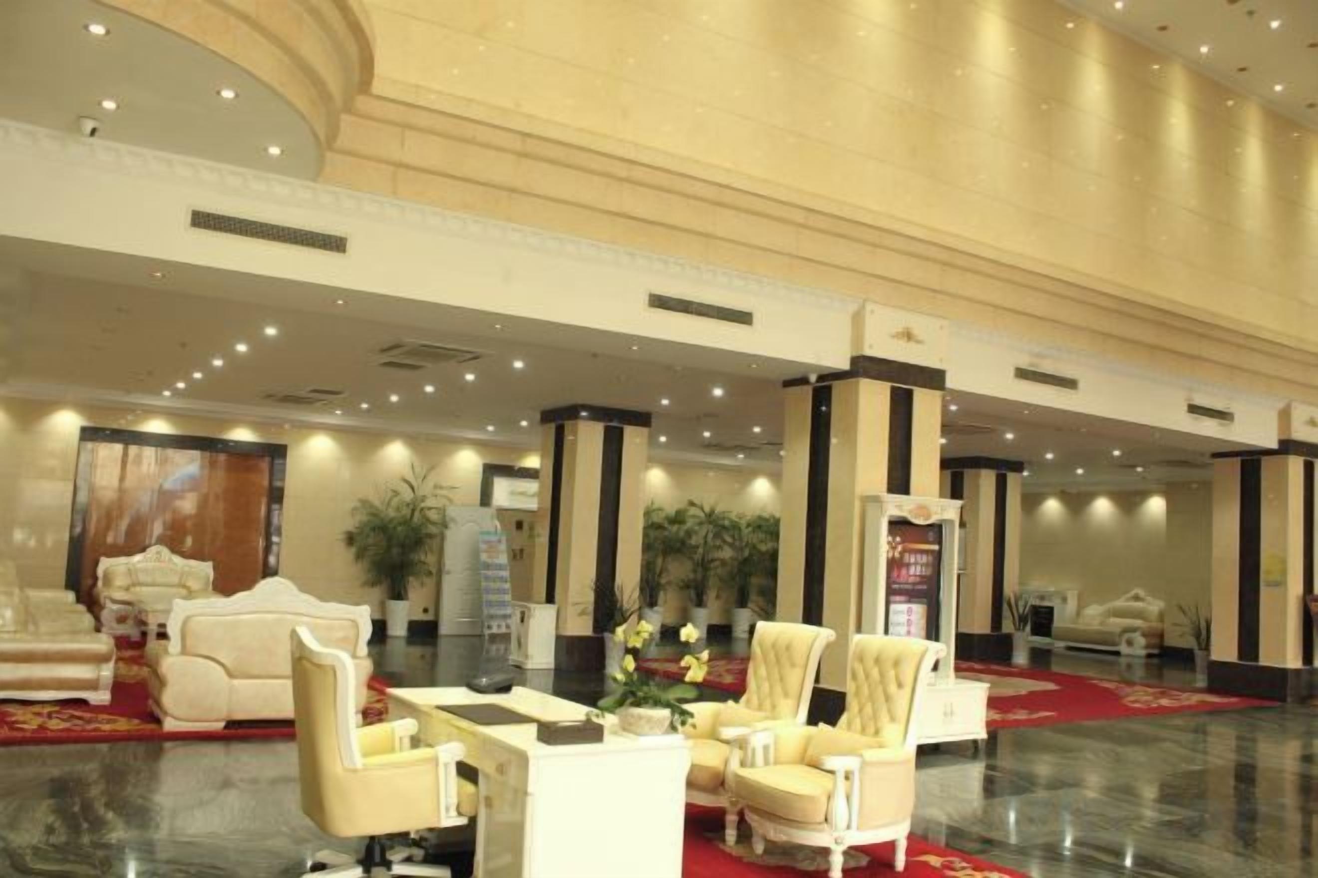 A lobby with a marble floor, plush seating, and a red carpet.