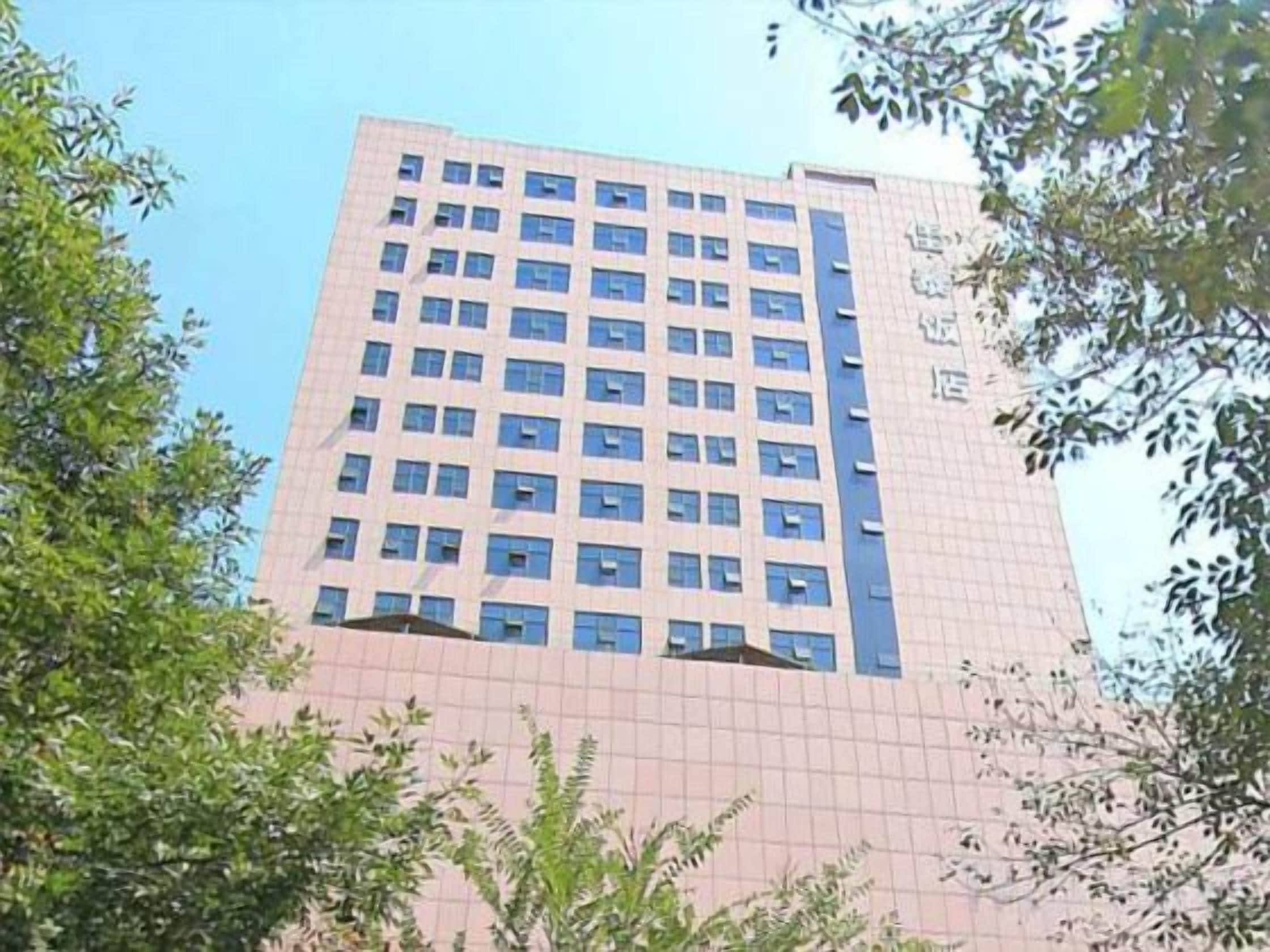 A multi-story building with a grid of windows and a visible fire escape on the right side.
