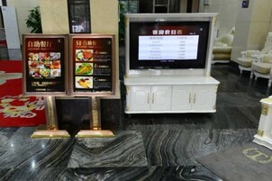 Un restaurante con un cartel de menú y un televisor mostrando una carta.