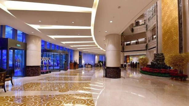 A spacious lobby with a patterned floor, a reception desk, and a staircase leading to upper levels. - Guidu Hotel Beijing (Beijing)