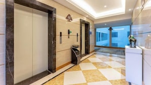 A hotel lobby with a checkered floor, a reception desk, a trash bin, and a wall-mounted sign. - GreenTree Inn (Feicheng Xincheng Road) (Feicheng)