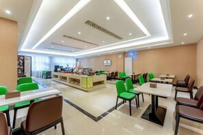 A hotel dining area with tables and chairs, a reception desk, and a counter. - GreenTree Inn (Feicheng Xincheng Road) (Feicheng)