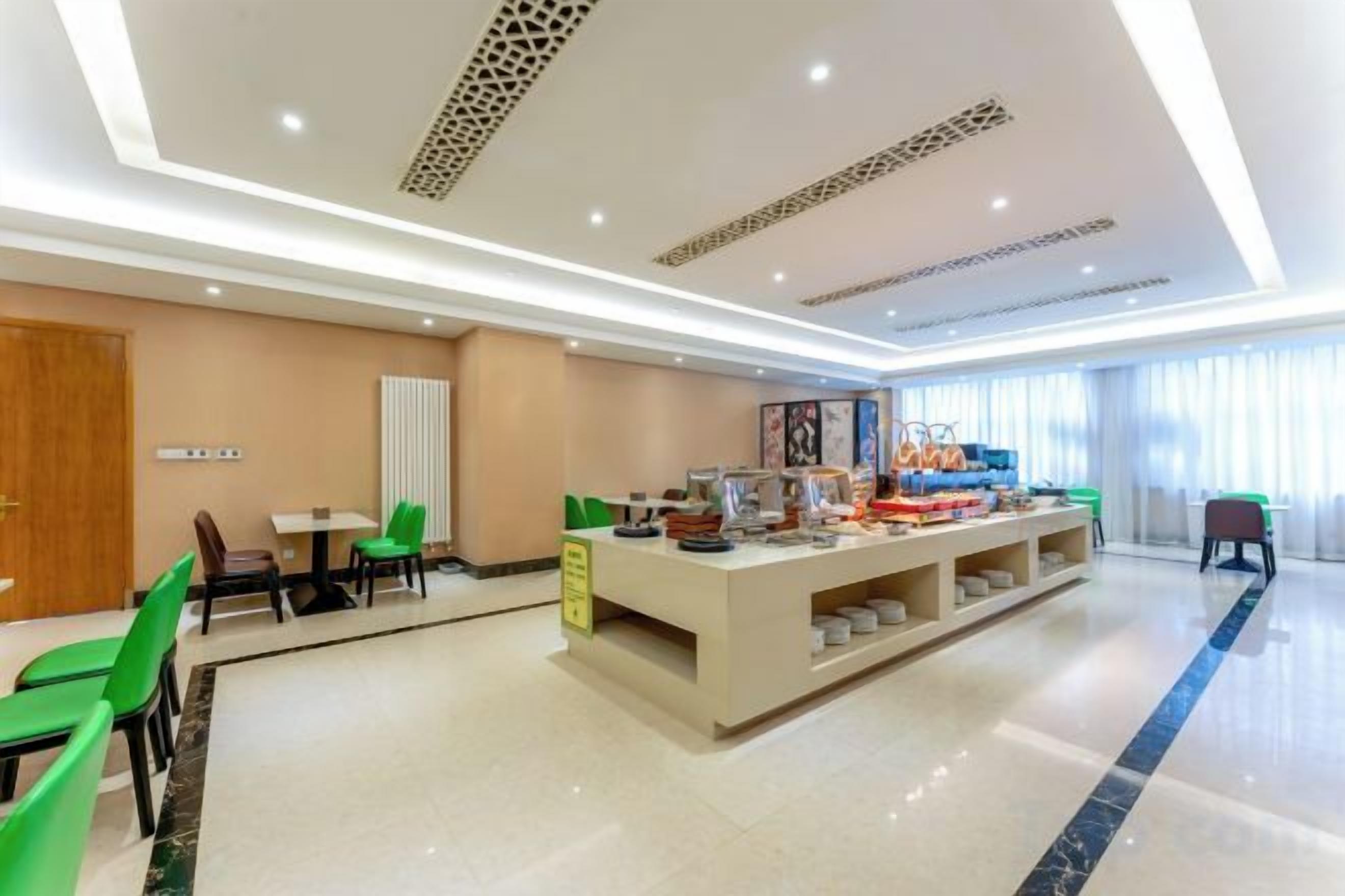 Un vestíbulo de hotel con mostrador de recepción, zona de estar y bufé.