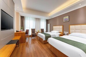 A hotel room with two beds, a desk, a TV, and a seating area with chairs and a table. - GreenTree Inn (Feicheng Xincheng Road) (Feicheng)