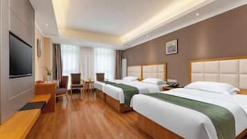 A hotel room with two beds, a desk, a chair, a TV, and a window with curtains.
