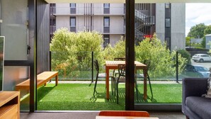 Een modern appartement met balkon, eettafel en een bank.