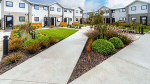 A modern residential complex with multiple two-story houses, a central paved walkway, and landscaped gardens. - City Escape - Near New Brighton Beach & He Puna (Christchurch)
