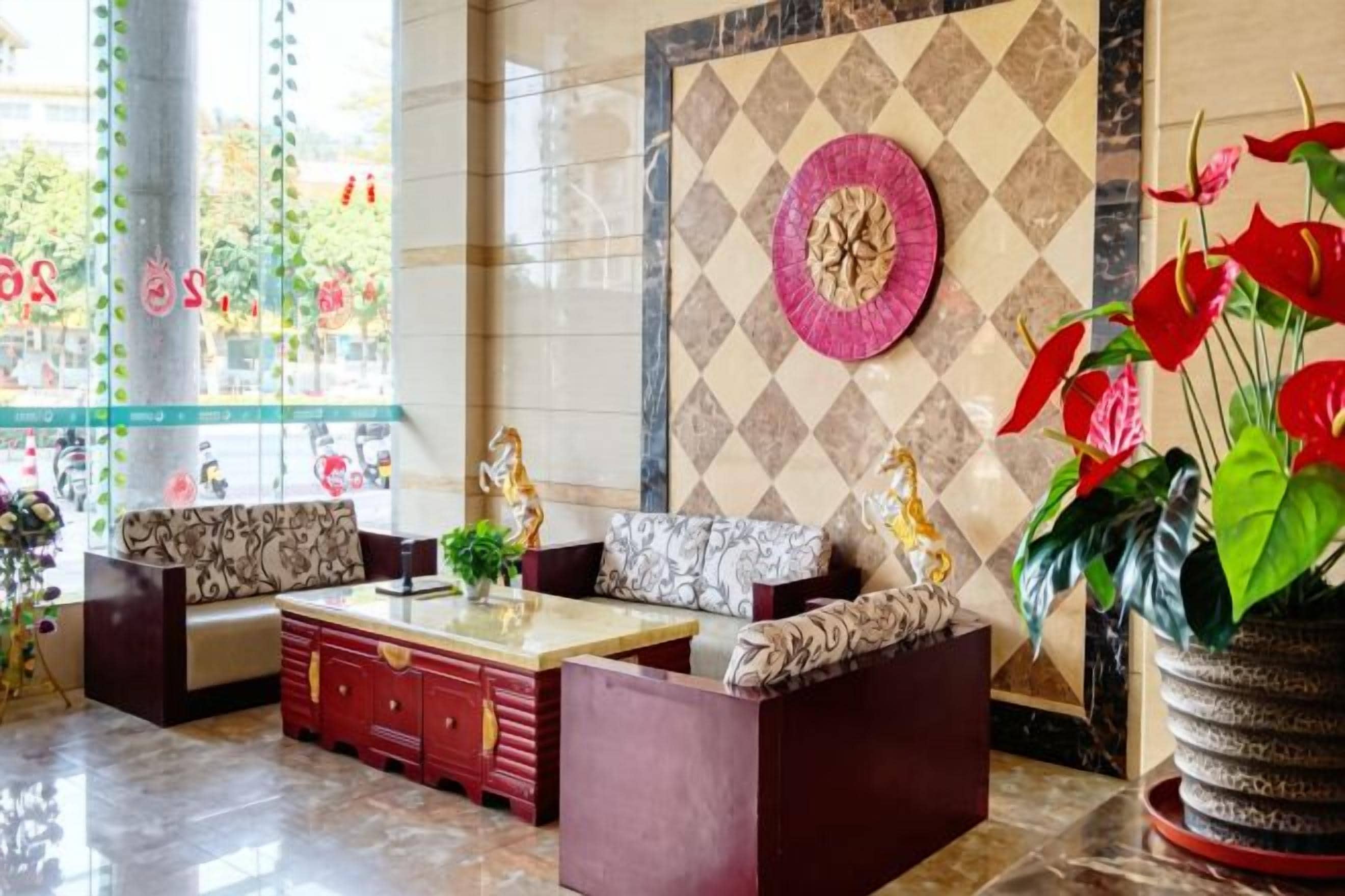 A lobby with a sofa set, a coffee table, and a decorative wall.