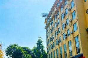 A multi-story building with a yellow facade and numerous windows. - Guangyuezhen Hotel (Baise High-Speed Railway Station) (Baise)