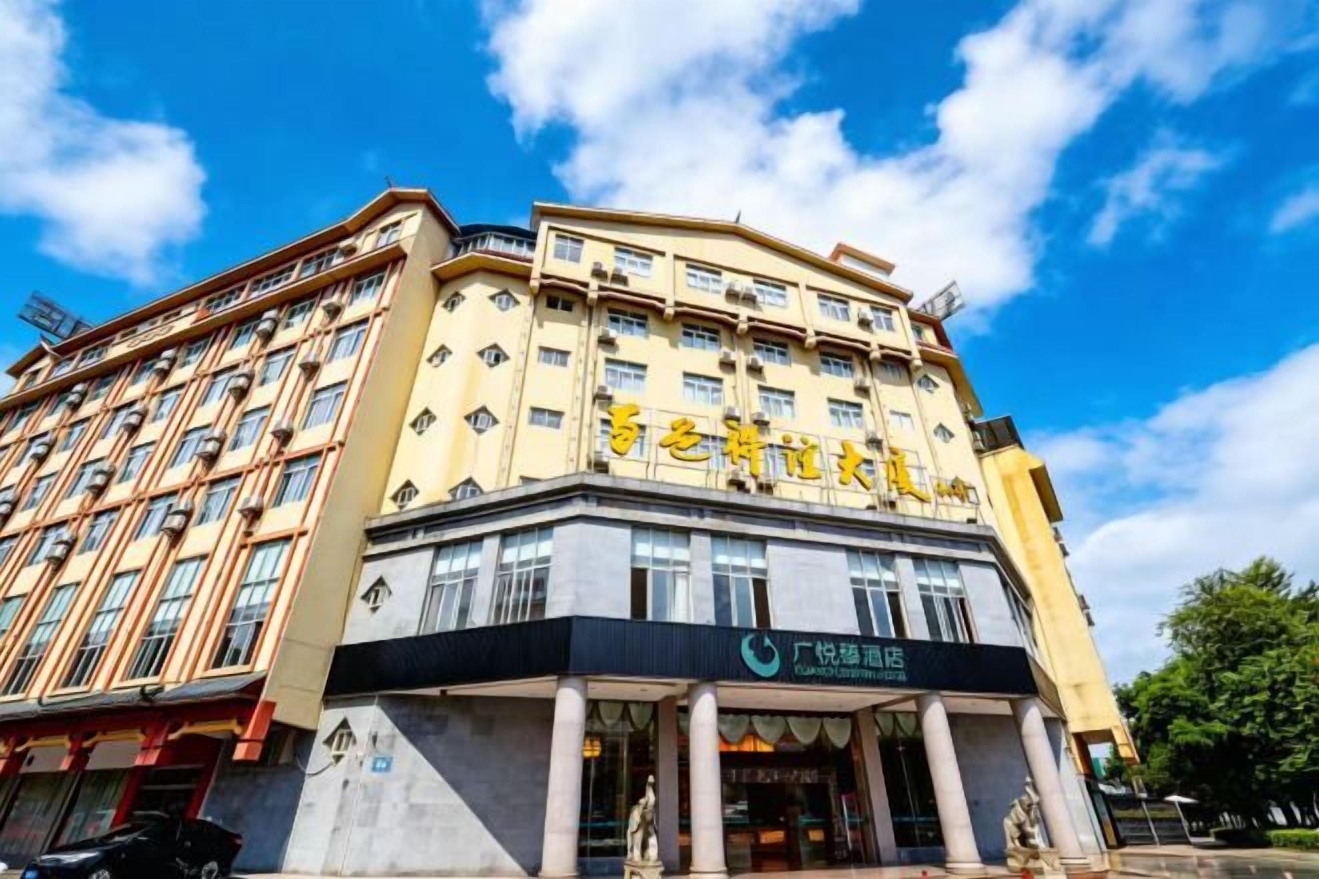 Un hotel de varios pisos con una entrada destacada y señalización.