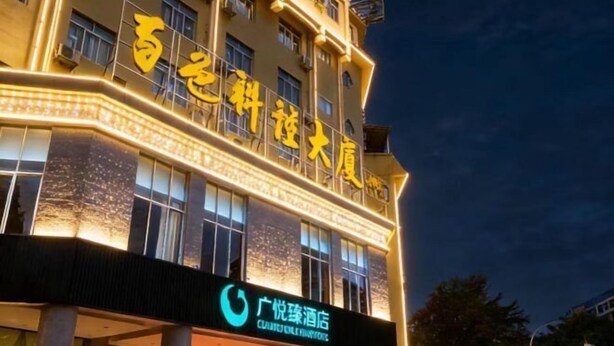 Un hotel con señalización iluminada y una entrada destacada.