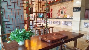 Una mesa de madera con sillas, una planta en maceta y una bandeja.