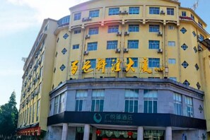 A multi-story building with a prominent sign in yellow characters. - Guangyuezhen Hotel (Baise High-Speed Railway Station) (Baise)