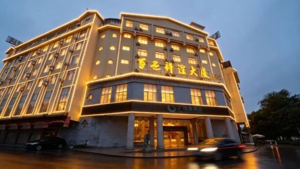 A multi-story hotel with illuminated signage and a well-lit entrance. - Guangyuezhen Hotel (Baise High-Speed Railway Station) (Baise)