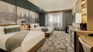 Habitación de hotel con dos camas, un escritorio, un televisor y un ventanal con cortinas.