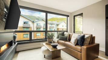 A modern living room with a leather sofa, a coffee table, and a fireplace.