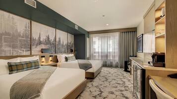 A hotel room with two beds, a desk, a coffee machine, and a large window with curtains.