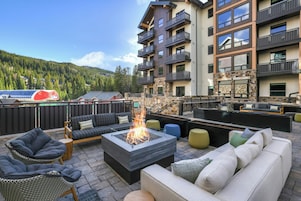 Une terrasse sur le toit avec des sièges extérieurs, un foyer et une vue sur une montagne.