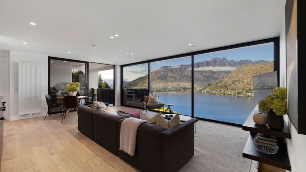 A modern living room with a large window offering a scenic mountain view. - The Bunker Charlie C (Queenstown)