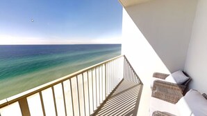 A balcony with a view of the ocean, wicker furniture, and a white railing. - Beach Front Resort with Gulf View in Panama City Beach with all amenities! (Panama City Beach)