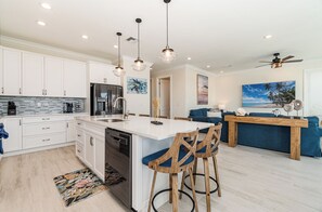 Enjoy dining or socializing at the central island with bar stools, or relax in the adjacent dining area with a sofa and coffee table.