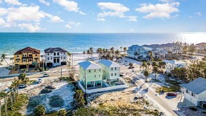 A coastal residential area with beachfront properties, including multi-story houses and a large building with a blue roof.