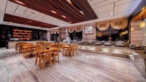 A spacious lobby with a marble floor, wooden seating, and a modern ceiling design. - Harmonious Qianjin Hotel (Kaili)