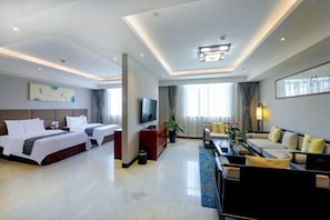 Una habitación de hotel con cama, televisión, sofá y una mesa de centro.