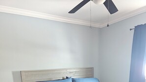 A bedroom with a bed, a nightstand, and a ceiling fan. - Redfish 'n Relaxation (Aransas Pass)