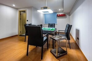Un espace repas comprenant une table, des chaises et un luminaire suspendu au plafond.