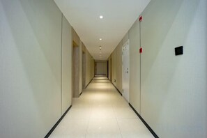 A long, narrow hallway with doors on both sides, leading to rooms. - GreenTree Inn (Chongming Nanmen) (Shanghai)