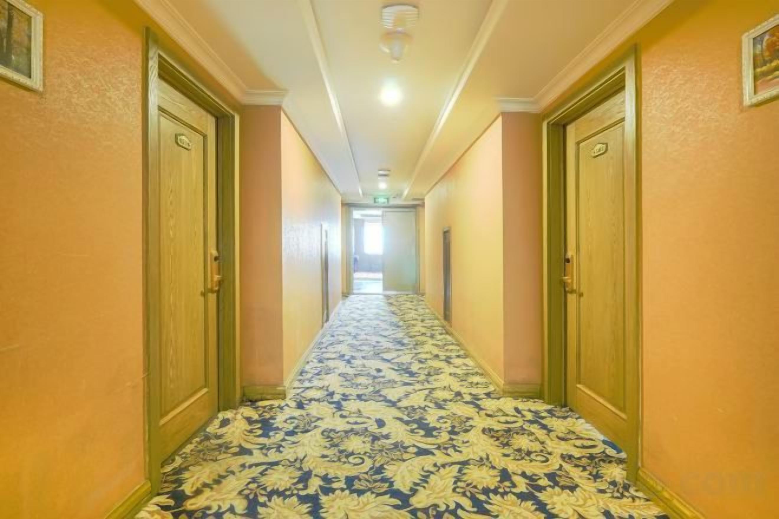 Un pasillo de hotel con pisos alfombrados y puertas a ambos lados.