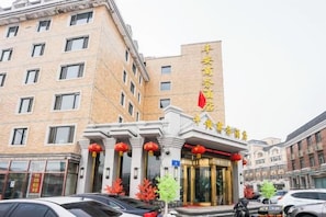 A hotel with a prominent entrance, multiple floors, and a flag. - Ping'an Business Hotel (Harbin)
