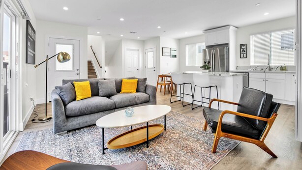 Un salon moderne avec un canapé gris, une table basse et un tapis à motifs.