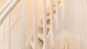A white spiral staircase with a handrail and a light switch on the wall. - Charming 4 Bedroom Home Near Oxford (Oxford)