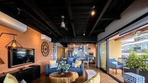 Un salon moderne avec un téléviseur, des canapés et une table basse.