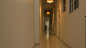 A corridor with a tiled floor and a hanging pendant light.