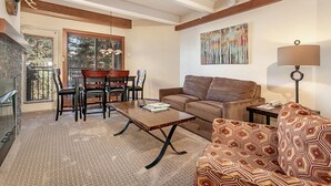 Ein Wohnzimmer mit einer Couch, einem Couchtisch und einem Essbereich mit Stühlen und einem Tisch.